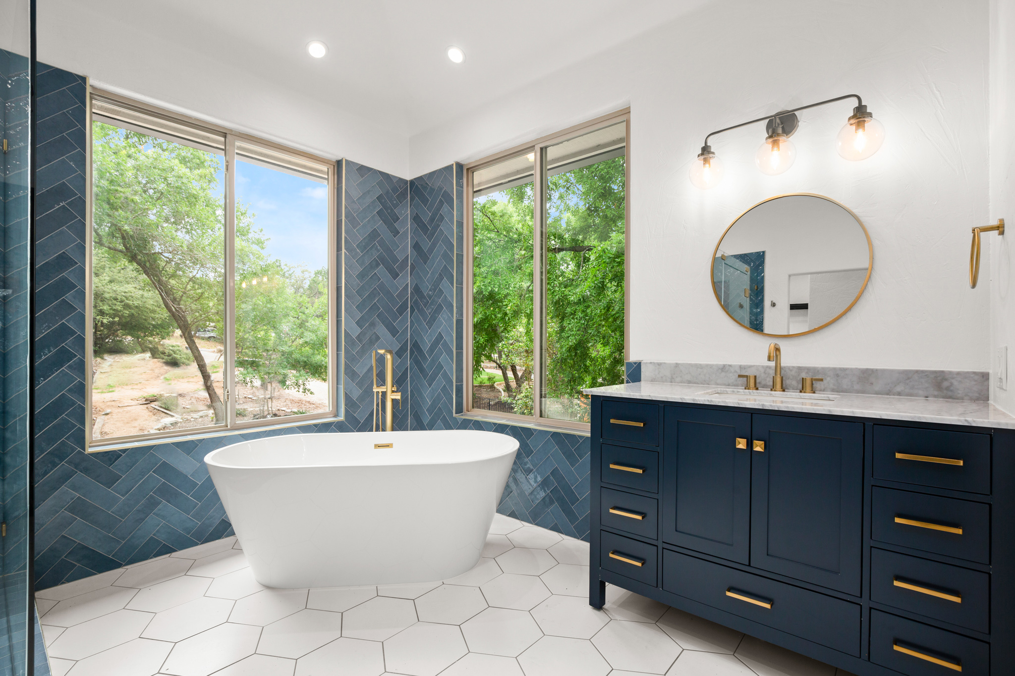 Luxury bathroom renovation. New bathroom tile, updated cabinets and furnishings, and large glass windows.